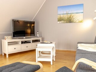 Gemütliches und helles Wohnzimmer mit integriertem Essbereich und schicker Küchenzeile