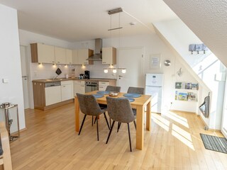 Gemütliches und helles Wohnzimmer mit integriertem Essbereich und schicker Küchenzeile