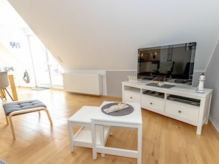 Gemütliches und helles Wohnzimmer mit integriertem Essbereich und schicker Küchenzeile