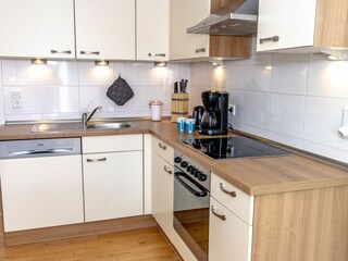 Gemütliches und helles Wohnzimmer mit integriertem Essbereich und schicker Küchenzeile