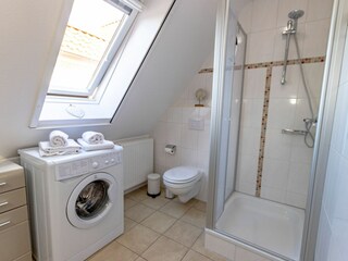 Helles Badezimmer mit Dusche, WC und Waschmaschine