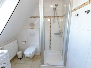 Helles Badezimmer mit Dusche, WC und Waschmaschine