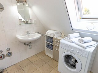 Helles Badezimmer mit Dusche, WC und Waschmaschine