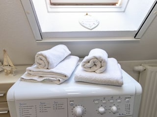 Helles Badezimmer mit Dusche, WC und Waschmaschine