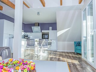 Großer Wohn- und Essbereich mit integrierter Küchenzeile und Balkon