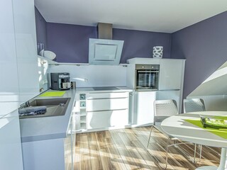 Großer Wohn- und Essbereich mit integrierter Küchenzeile und Balkon