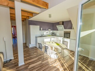 Großer Wohn- und Essbereich mit integrierter Küchenzeile und Balkon