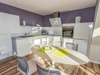 Großer Wohn- und Essbereich mit integrierter Küchenzeile und Balkon