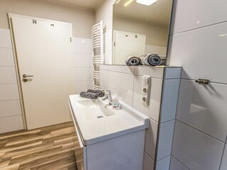 Modernes Badezimmer mit großer Dusche, Sauna und Waschmaschine