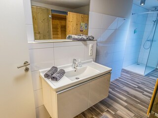 Modernes Badezimmer mit großer Dusche, Sauna und Waschmaschine