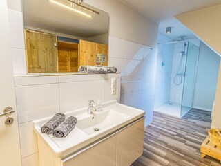 Modernes Badezimmer mit großer Dusche, Sauna und Waschmaschine