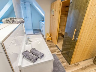 Modernes Badezimmer mit großer Dusche, Sauna und Waschmaschine