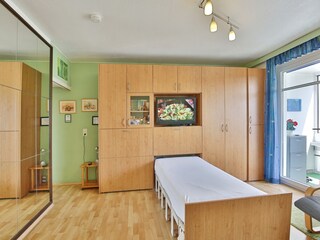 Die Wohnzimmerschrankwand mit einem ausgefahrenen Bett