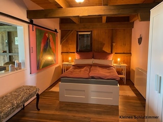 kleines Schlafzimmer mit Fenster zum Stall