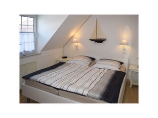 Schlafzimmer mit Doppelbett und Schrank