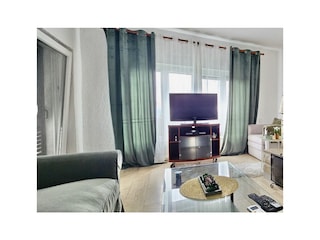 Wohnraum mit gemütlicher Sofa und SAT-TV