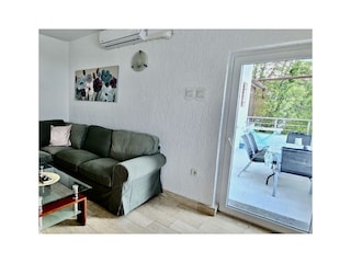 Wohnraum mit gemütlicher Sofa, Terrasse mit Meerblick
