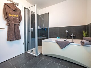 Badezimmer neben den beiden Schlafzimmern mit Whirlpoolbadewanne und bodengleicher Dusche