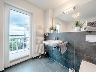 Badezimmer neben den beiden Schlafzimmern mit Whirlpoolbadewanne und bodengleicher Dusche