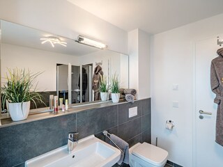 Badezimmer neben den beiden Schlafzimmern mit Whirlpoolbadewanne und bodengleicher Dusche