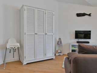 Wohnraum mit großem Kleiderschrank und Hochstuhl