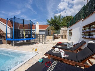 Der Pool mit Sonnenliegen