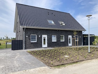 Hausfront mit großem Parkplatz