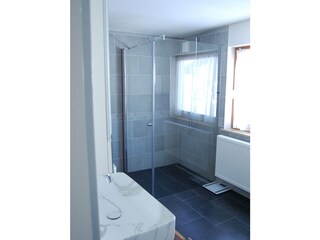 Badezimmer mit begehbarer Dusche und Toilette im OG
