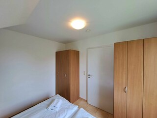Schlafzimmer mit Doppelbett und Kleiderschrank