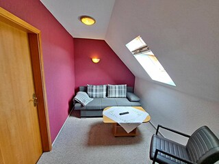 Wohnzimmer im 1. OG mit Couch (Schlaffunktion, Aufbettungsmöglichkeit für 2 weitere Personen), TV