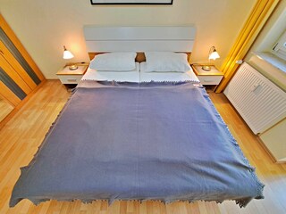 Schlafzimmer mit Doppelbett und Zugang zum Wintergarten