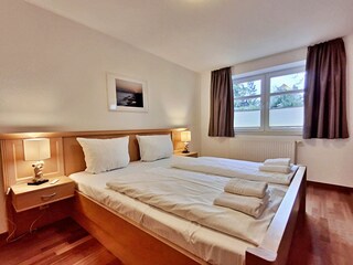 Schlafzimmer mit Doppelbett und hochwertigem Frame-TV