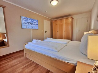 Schlafzimmer mit Doppelbett und hochwertigem Frame-TV