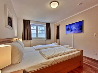 Schlafzimmer mit Doppelbett und hochwertigem Frame-TV