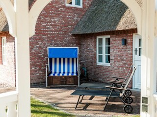 Der Blick aus dem Holzpavillon auf den Strandkorb. Hinter der Tür befindet sich der Wellnessbereich.