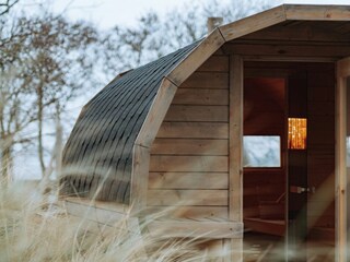 Relaxen Sie in der hauseigenen Fass-Sauna mit Strand-Ambiente!