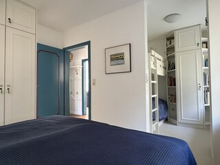 Schlafzimmer mit Einbauschrank und Blick zum Etagenbett