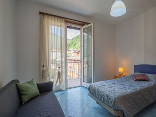 Schlafzimmer mit Einzelbett und Ausgang auf einen der Balkone