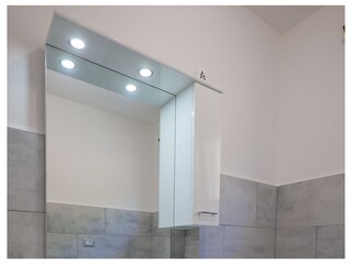 Freundliches Badezimmer mit Dusche, Waschmaschine und Fenster