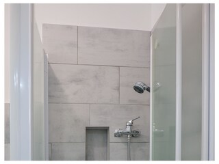 Freundliches Badezimmer mit Dusche, Waschmaschine und Fenster