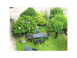 Ca. 80 m² großer Gemeinschaftsgarten mit Sitzgelegenheit und Liegestühlen