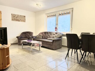 Blick in den Wohnbereich mit Ledercouch und Smart TV