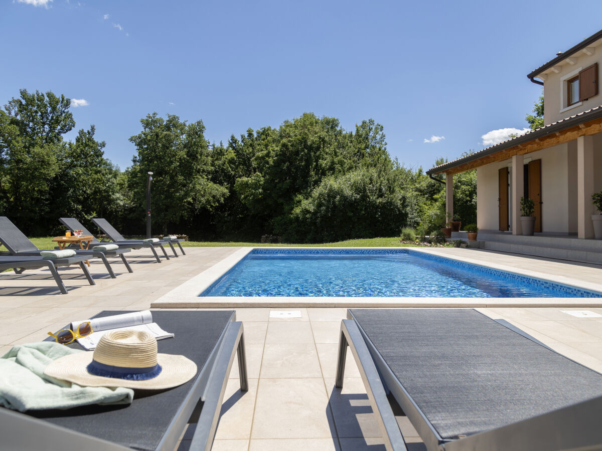 Wunderschöner Pool umgeben von Liegestühlen.