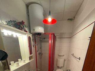 Badezimmer mit Dusche und Waschmaschine