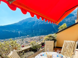 Ca. 10 m² großer Sonnenbalkon mit Markise und Sicht auf Cannobio, den See und die umliegenden Berge