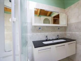 Freundliches, modernes Badezimmer mit Badewanne und integrierter Dusche sowie Fenster