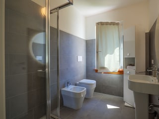 Badezimmer mit Dusche, Bidet und Fenster