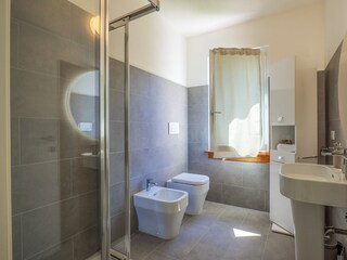 Badezimmer mit Dusche, Bidet und Fenster