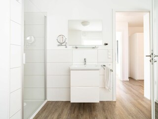 Badezimmer mit Sauna und ebenerdiger Dusche