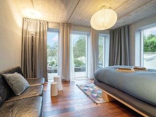 Schlafzimmer mit Doppelbett und Couch